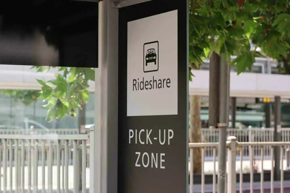 Roadside waiting area with Rideshare and Pick Up Zone sign