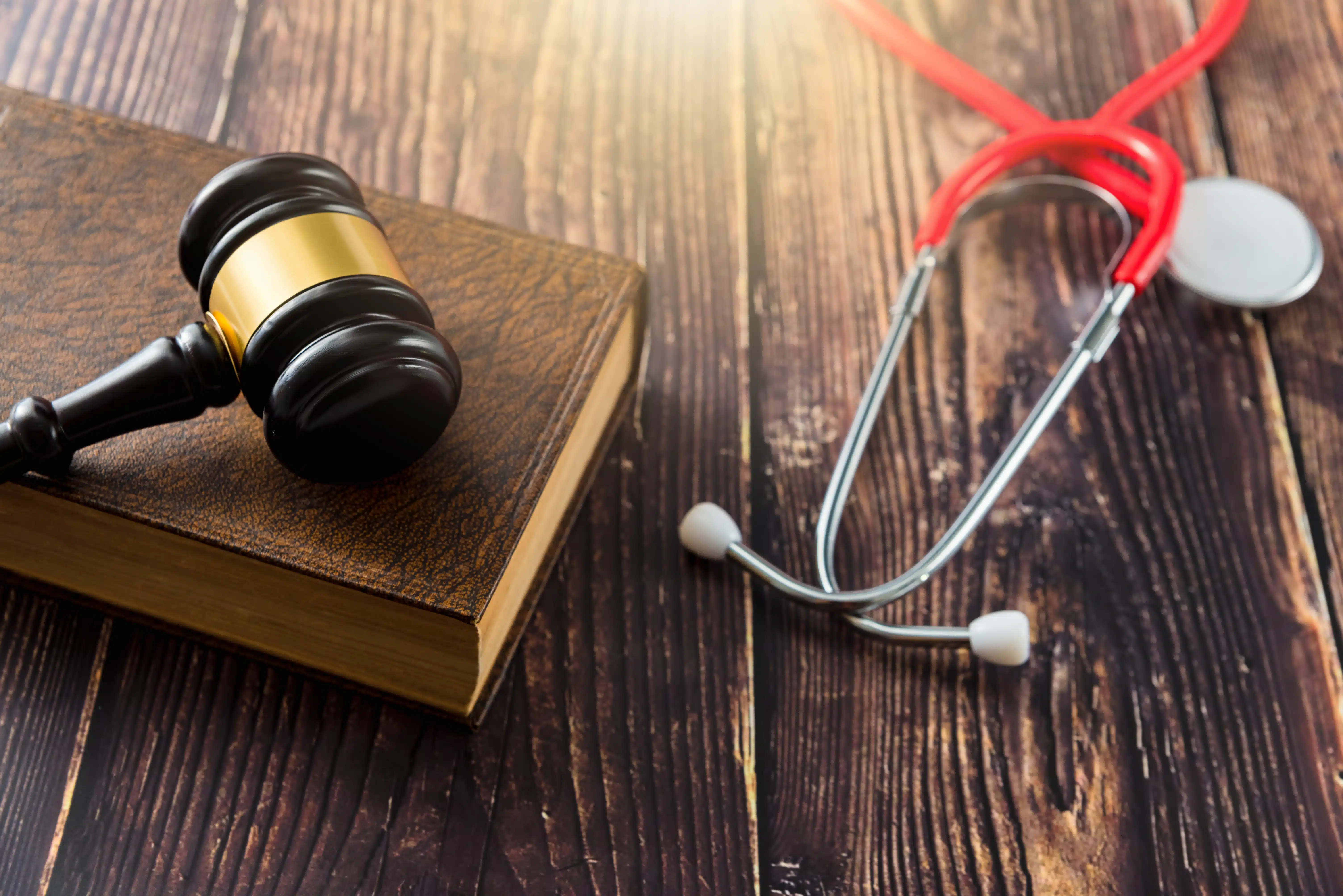 Gavel and book and stethoscope on a wooden table