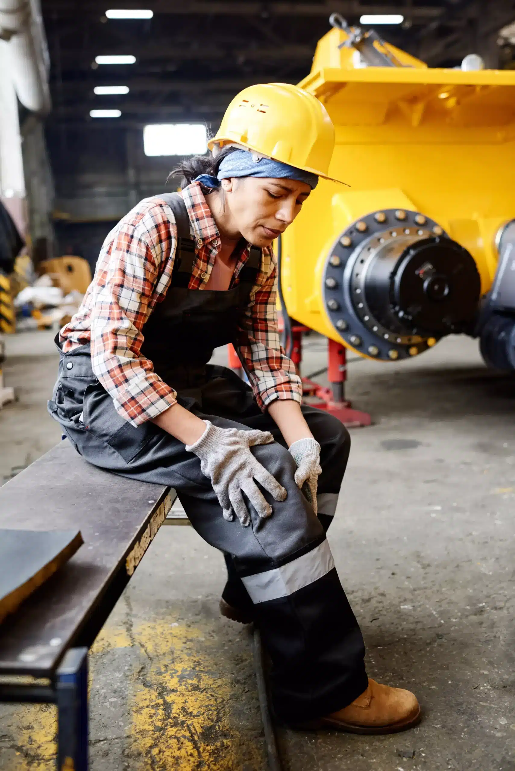 young female engineer touching her injured knee