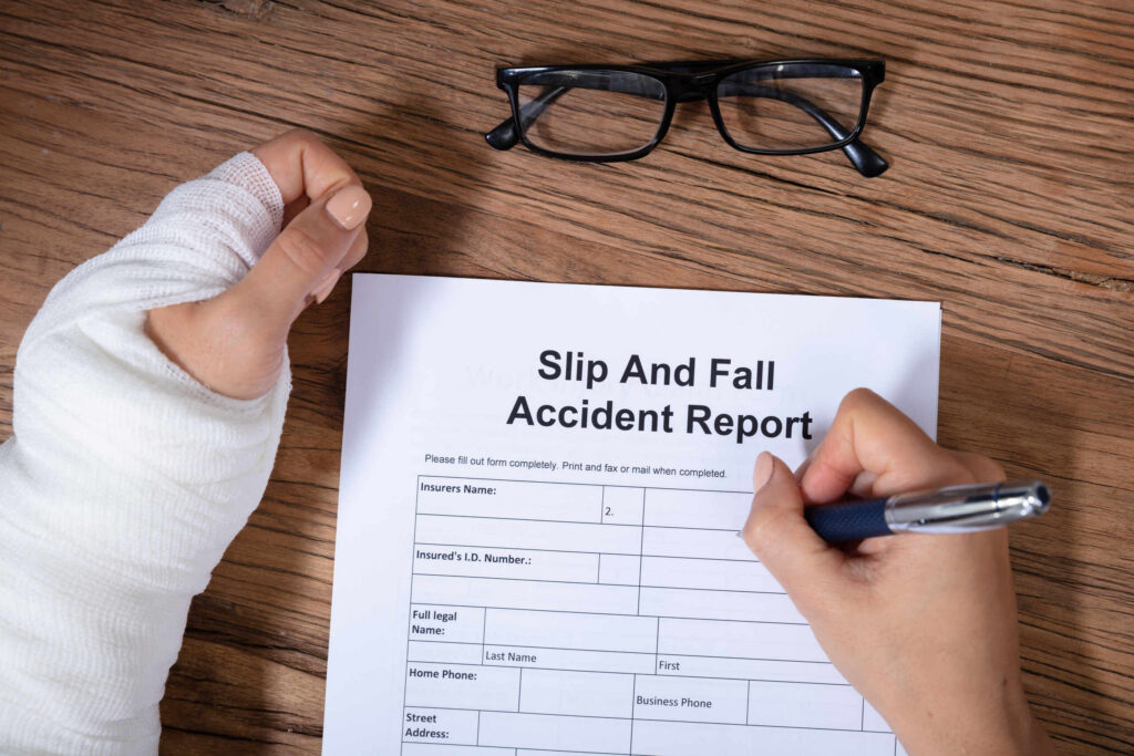 A victim documenting the details of a fall injury, illustrating the first step a premises liability lawyer takes to investigate claims involving road negligence or poor maintenance on public and private property.