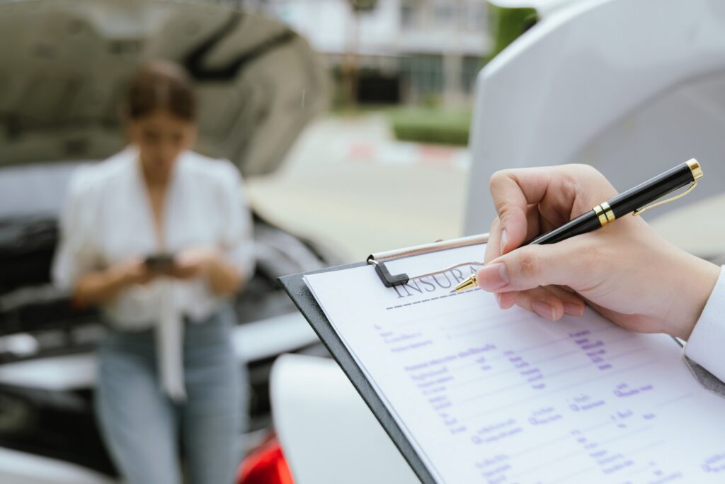 An insurance adjuster fills out a claim form while answering do I need PIP insurance in Florida for an injured driver.