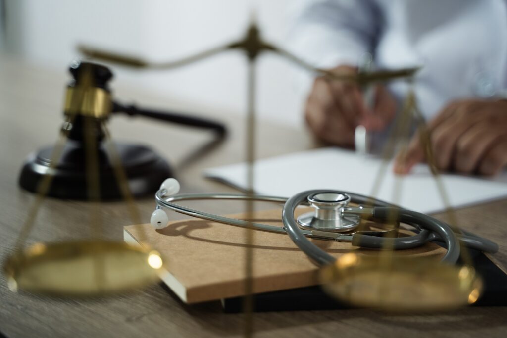 A medical stethoscope, balance scales, and a legal gavel on a desk, illustrating claims handled by a personal injury lawyer in Lake Worth.
