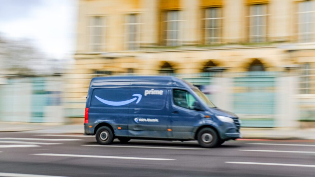 An Amazon Prime delivery van driving quickly along a road answering whether you can sue Amazon if a delivery driver hit you in Florida.