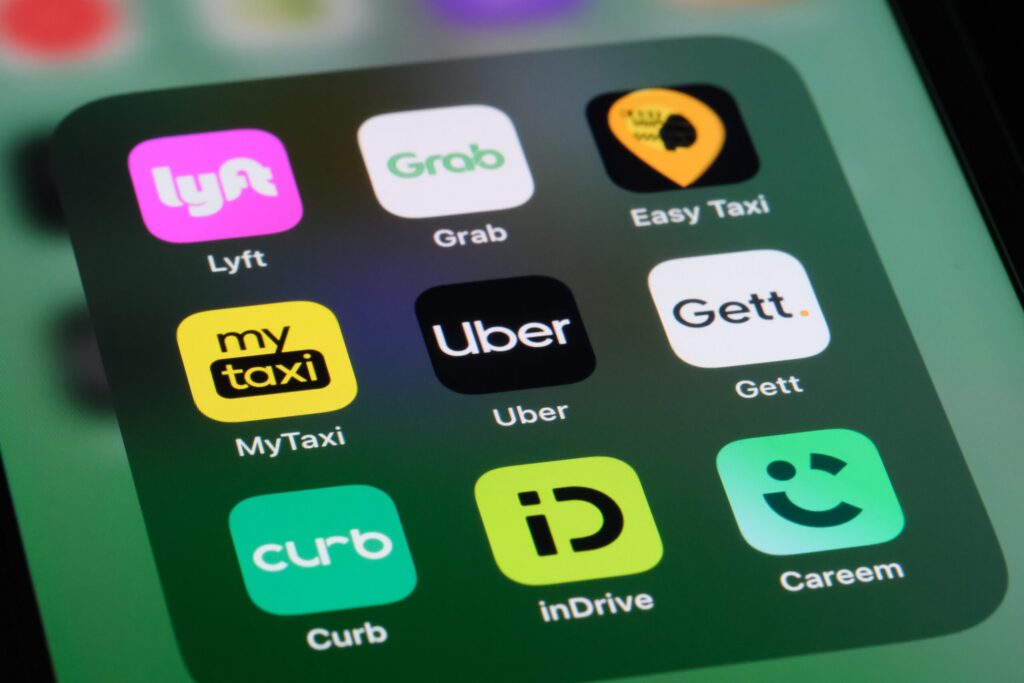 A smartphone screen displaying Uber and Lyft icons for victims seeking Palm Beach Gardens Uber & Lyft accident lawyers.
