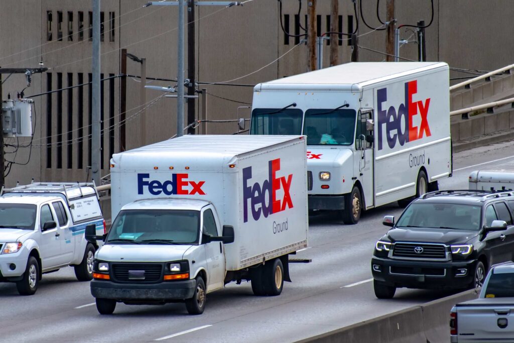 FedEx Ground delivery trucks driving in traffic representing options from West Palm Beach FedEx Truck Accident Lawyers.